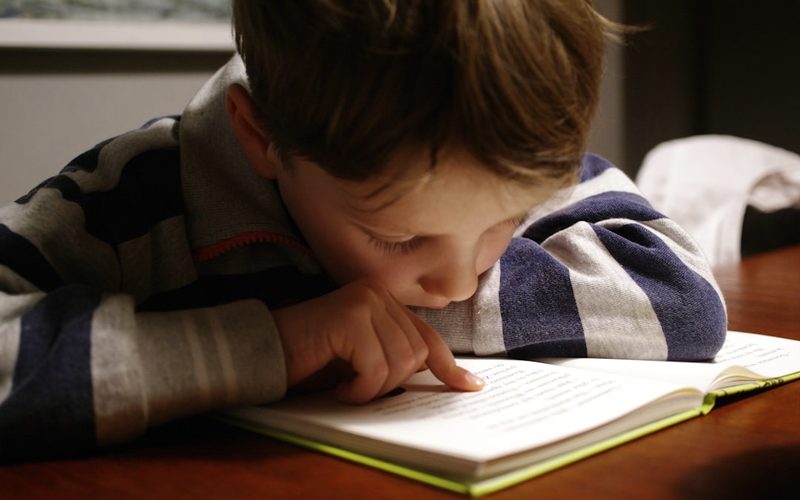 A child reading quietly in warm light.